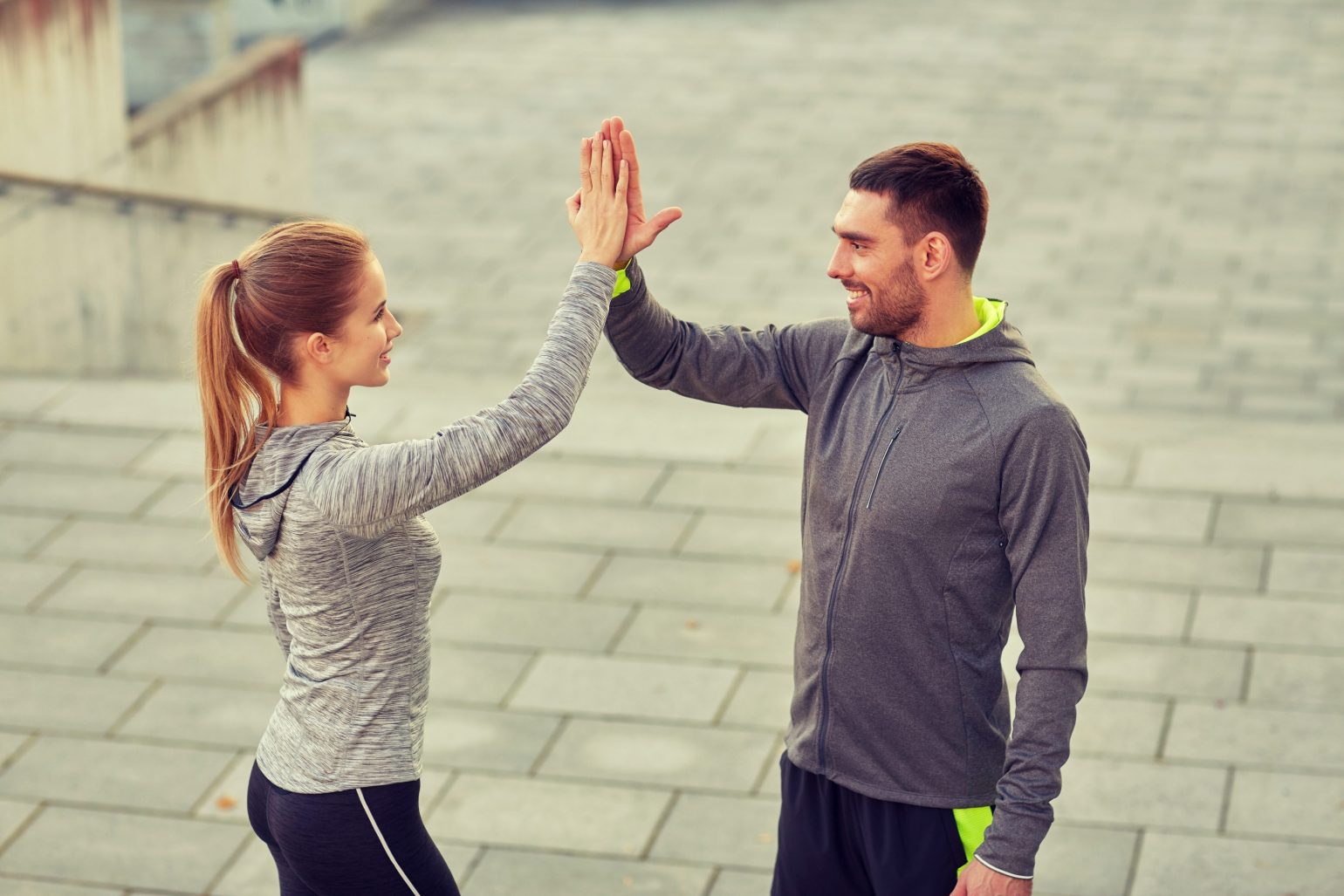happy couple giving high five outdoors